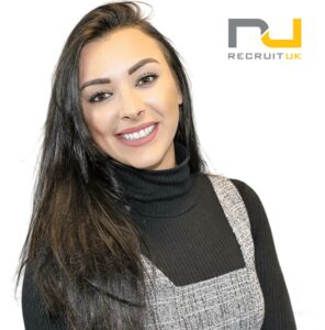 Member of staff smiling with the Recruit UK in the corner